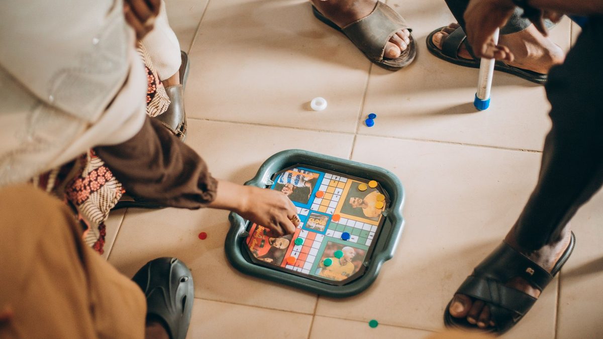 A group of children sitting on the floor playing a board game together