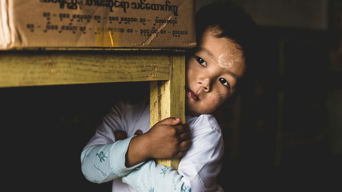 A child reaching into a box to choose a prize