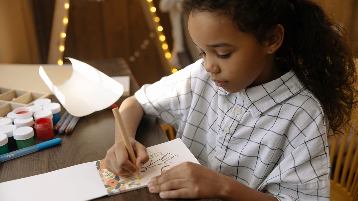 A child colouring in a picture with coloured pencils