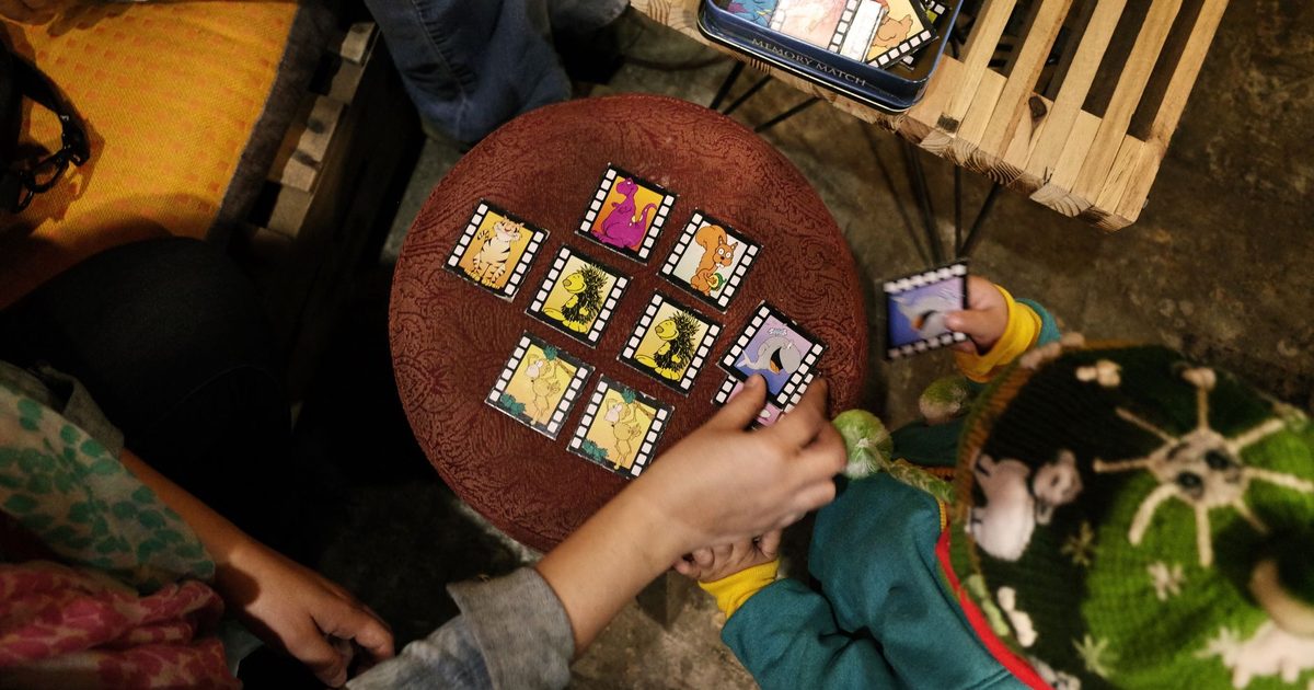 Children playing a card game together at a table
