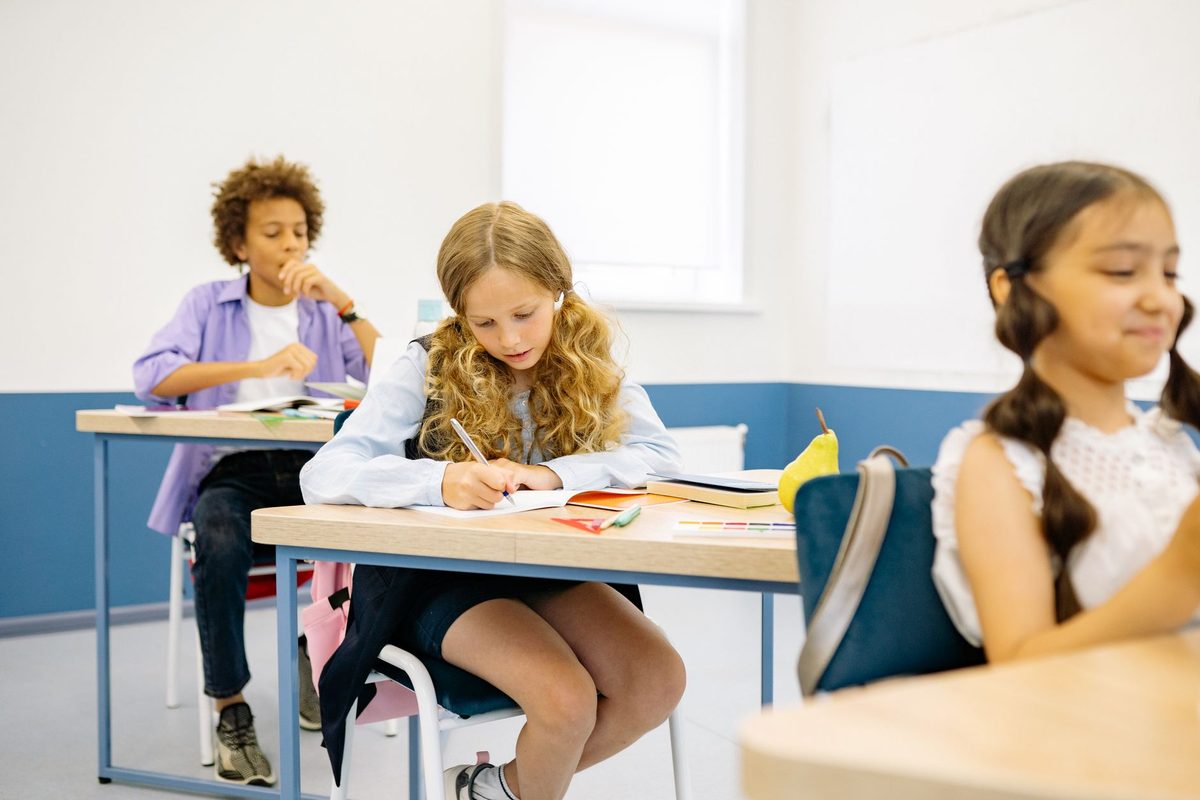 Pupils working quietly at individual desks in a bright classroom