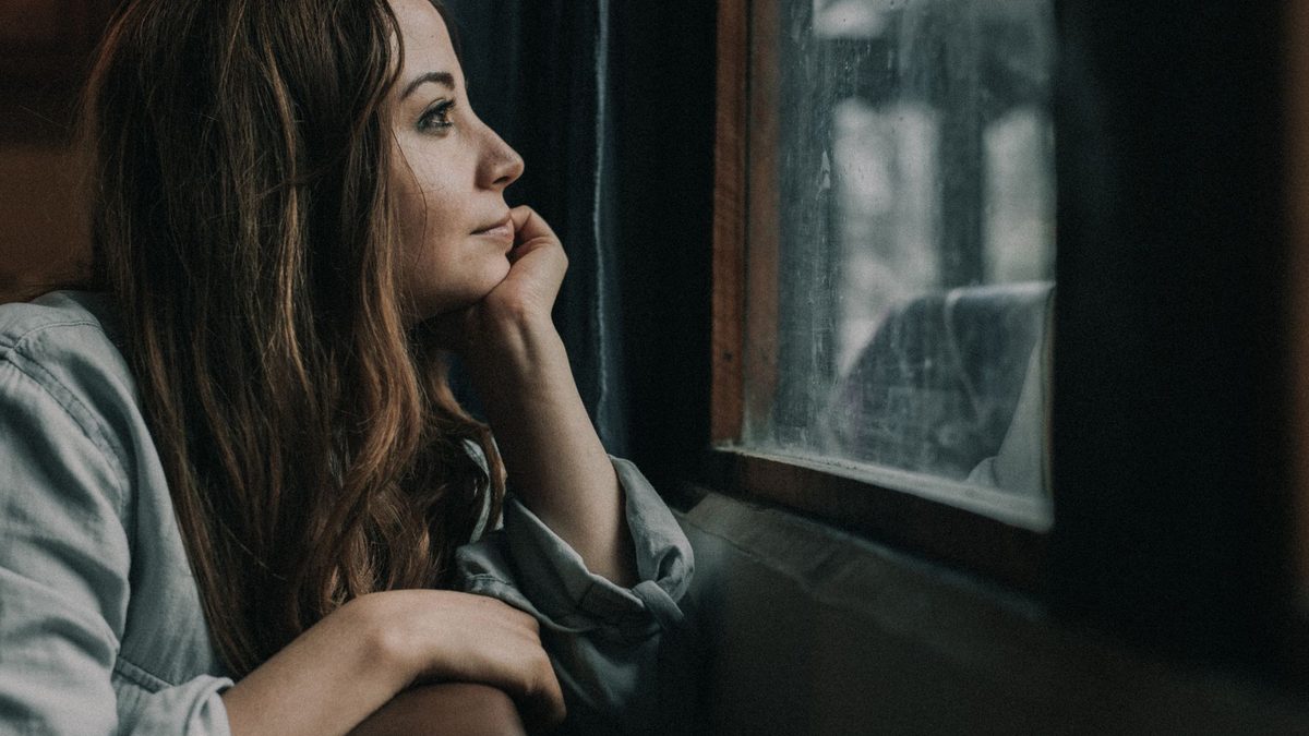 A person staring out of a window and daydreaming