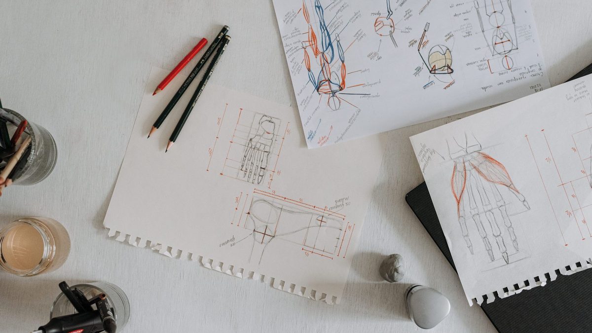 A hand drawing lines on paper with a pencil during a strategy game