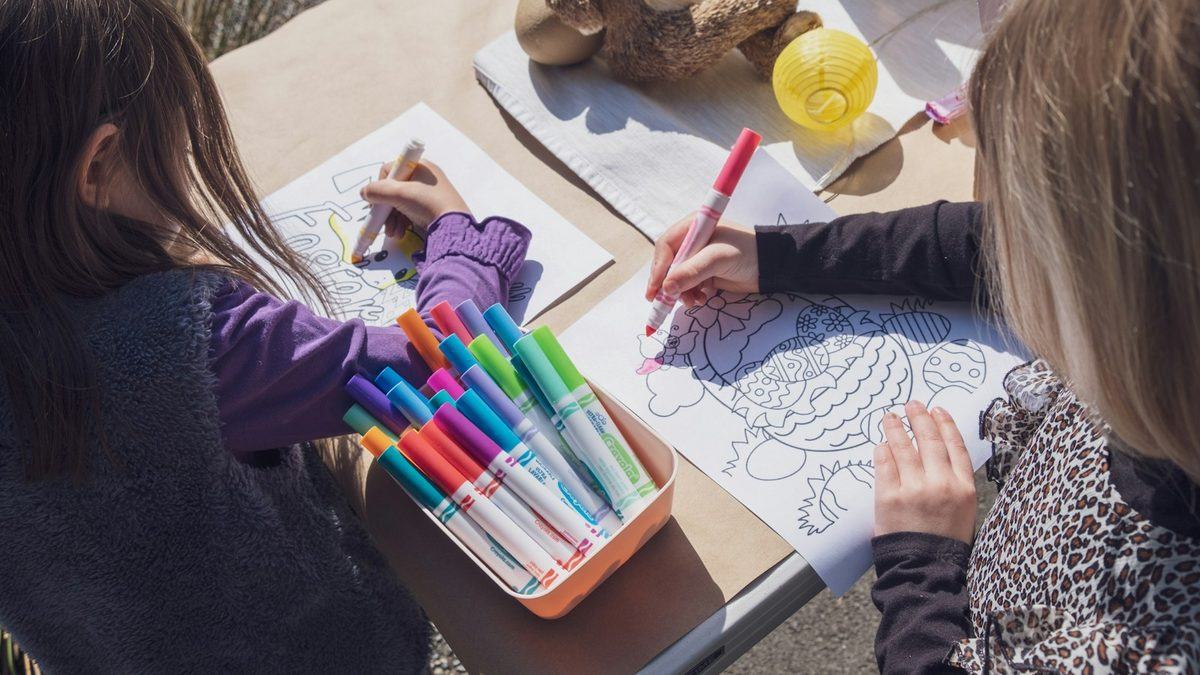 An adult and a child drawing together at a table