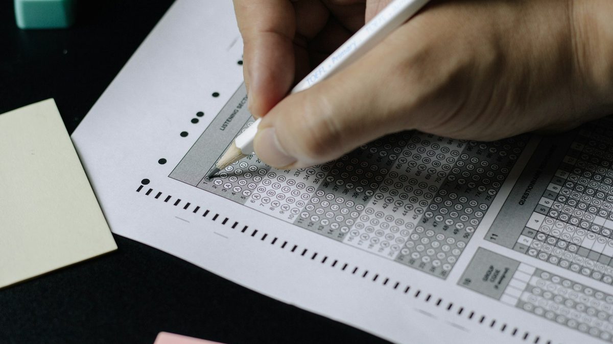 An exam desk laid out with paper and a pencil