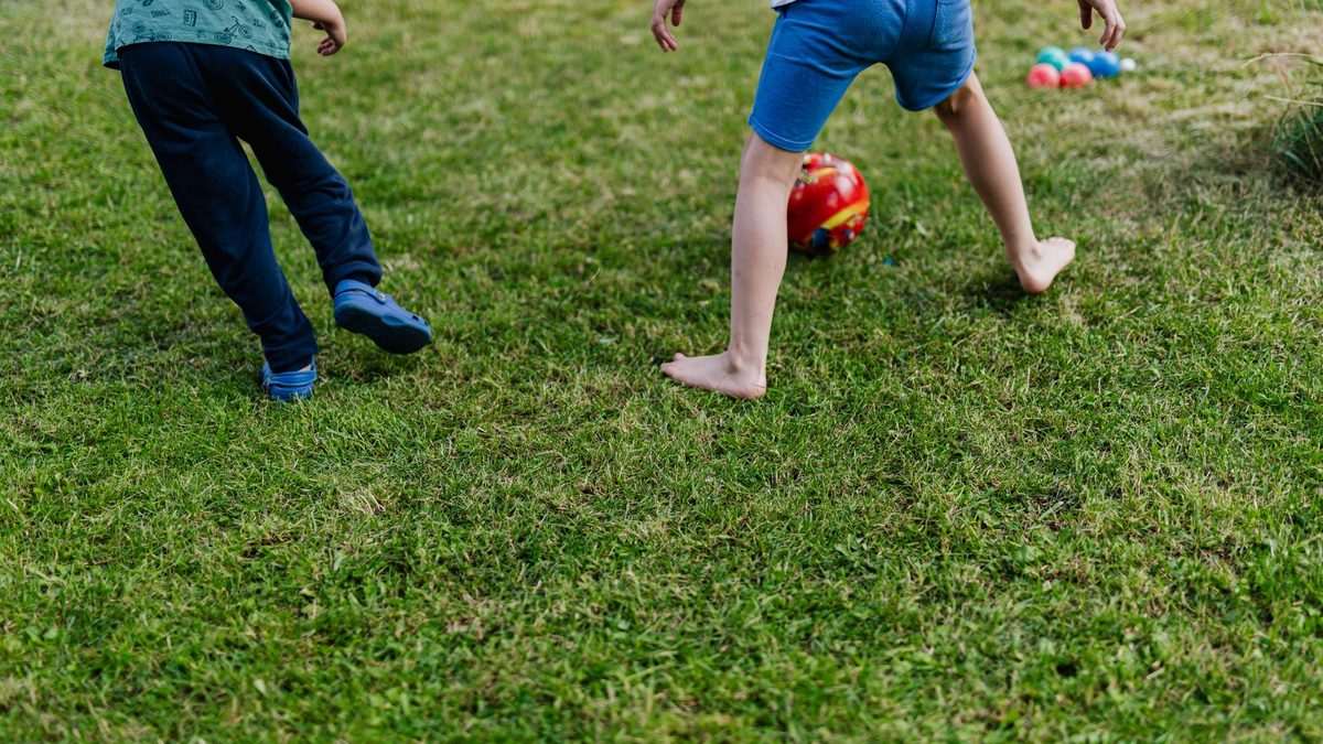 Children playing with a ball outdoors on a playground