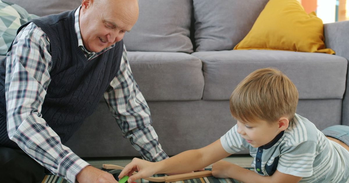 An older and a younger child playing a game together