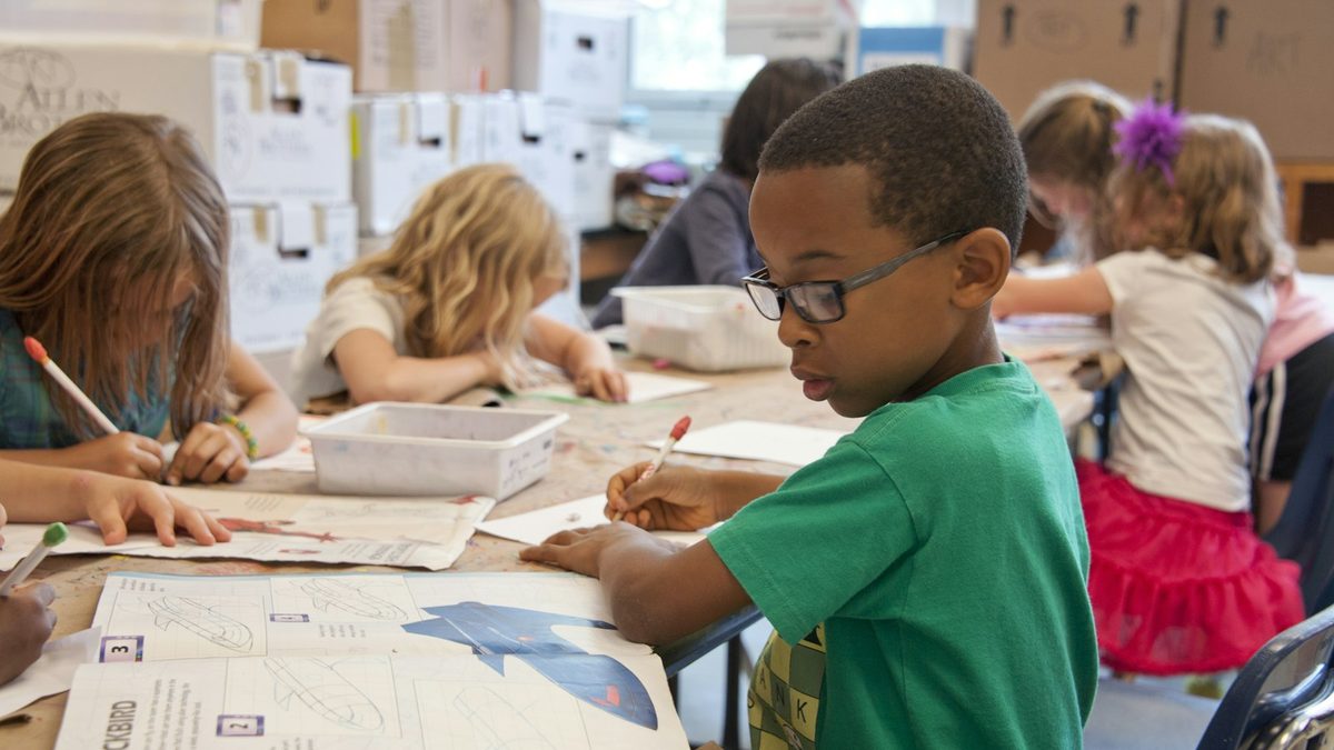 A child concentrating on a learning task at a table