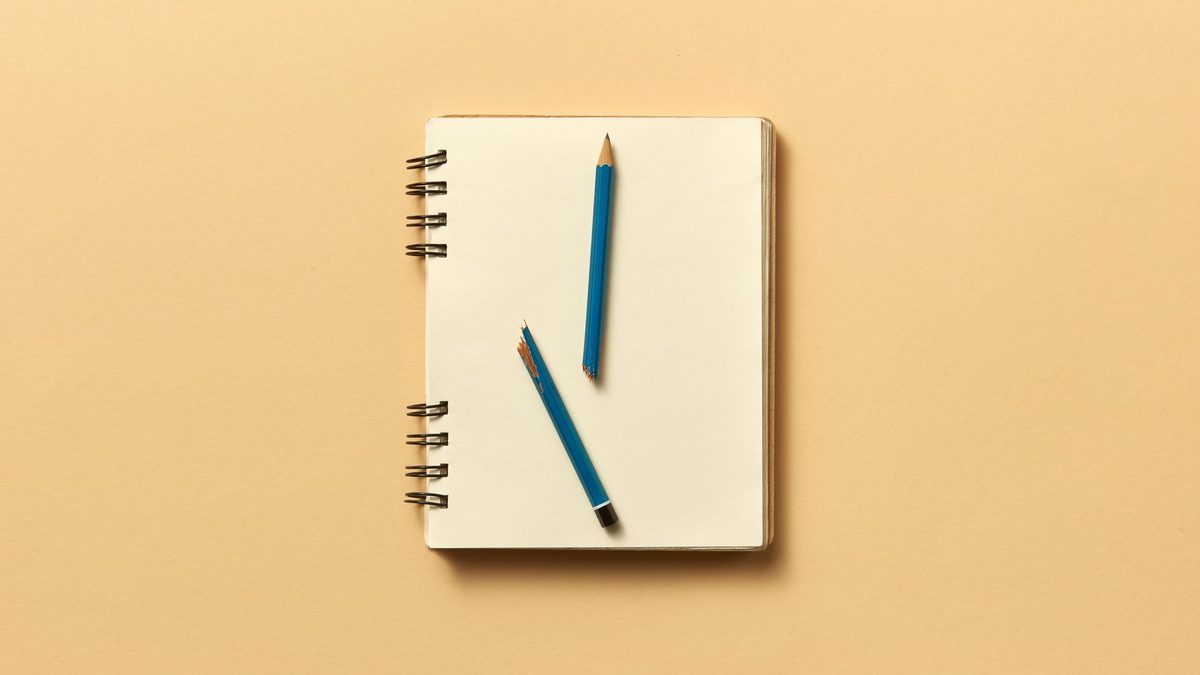 Pencils and a notebook arranged neatly from above