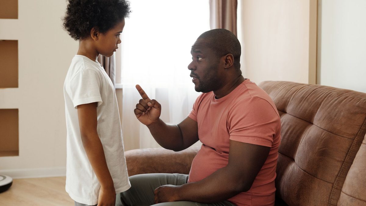 A parent sitting and talking with a child at home