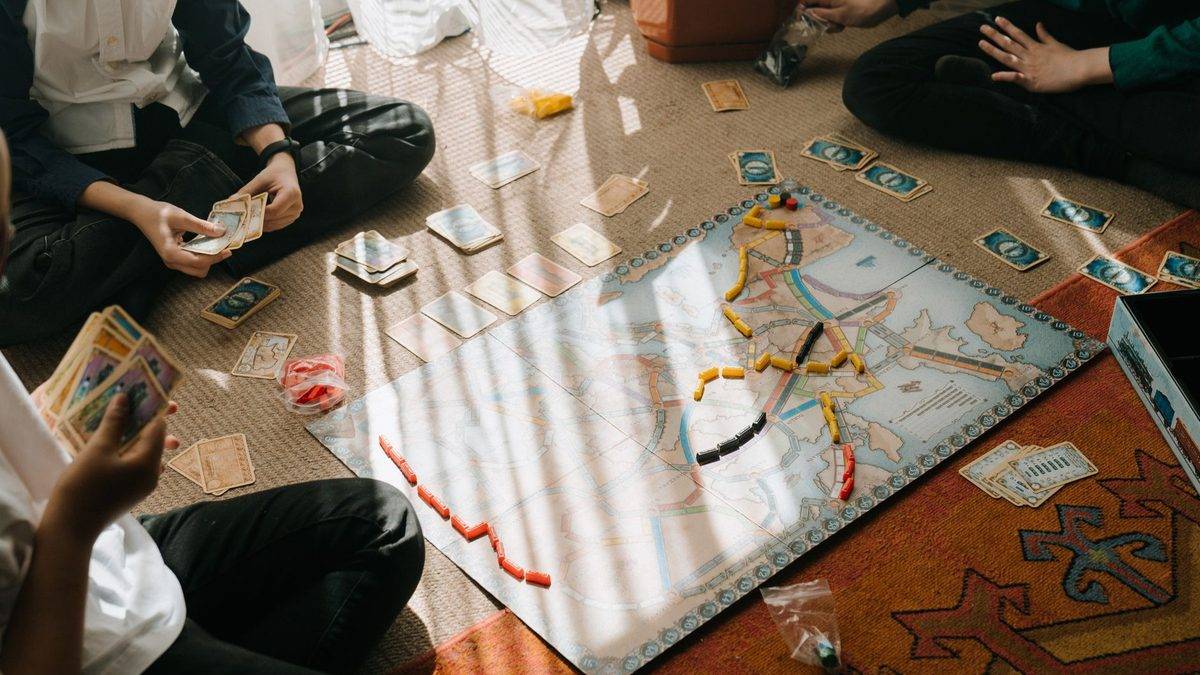 Children of different ages playing a board game together at a table
