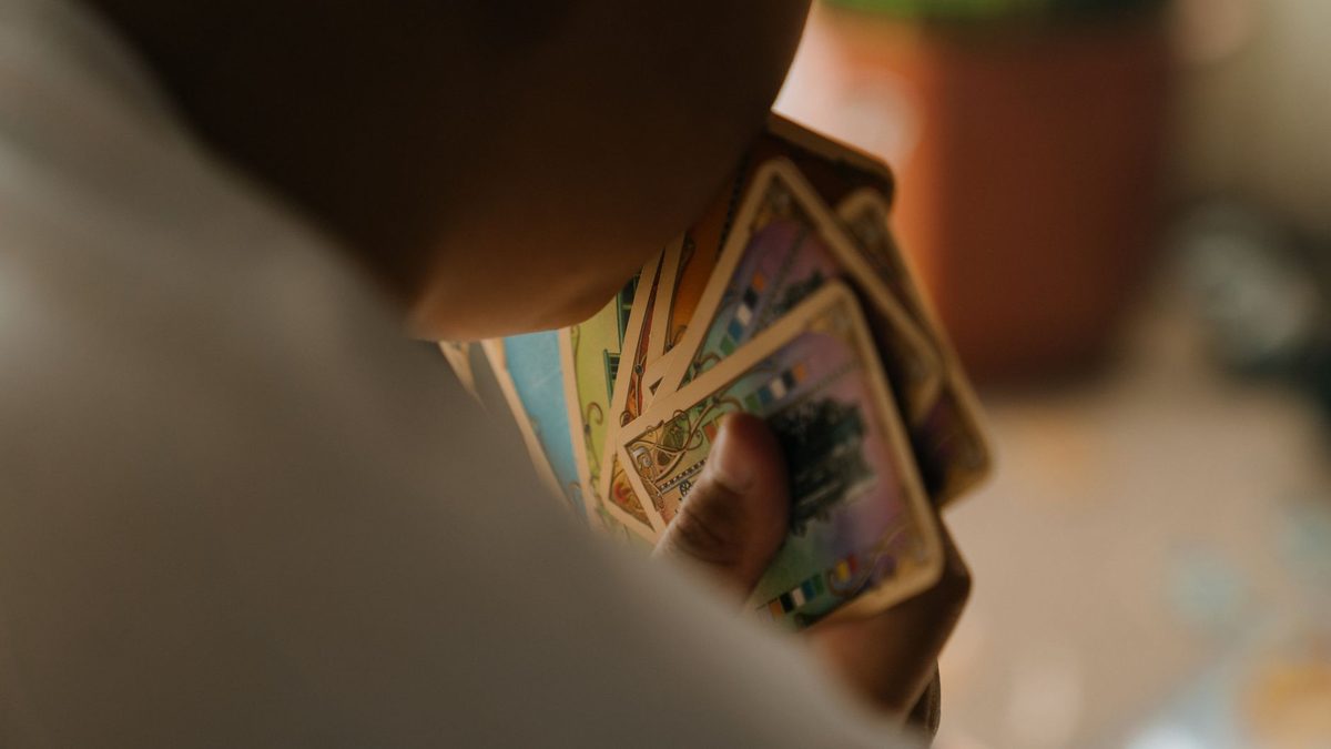 A child holding a hand of playing cards