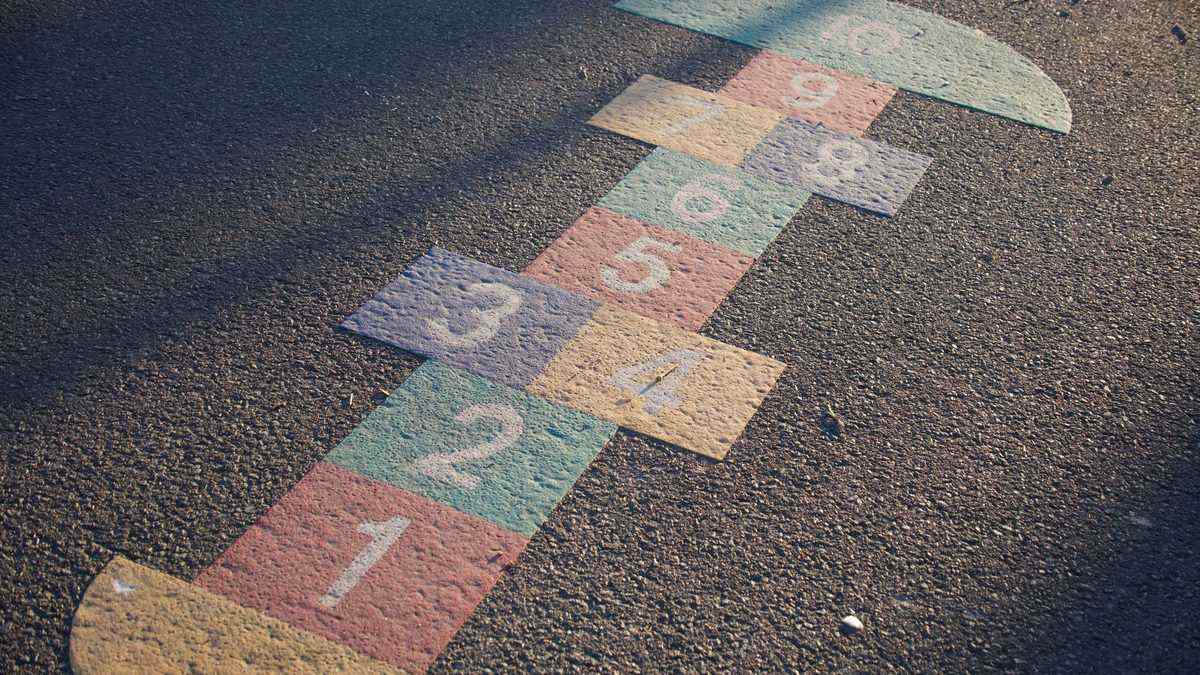 A hopscotch grid drawn in chalk on tarmac