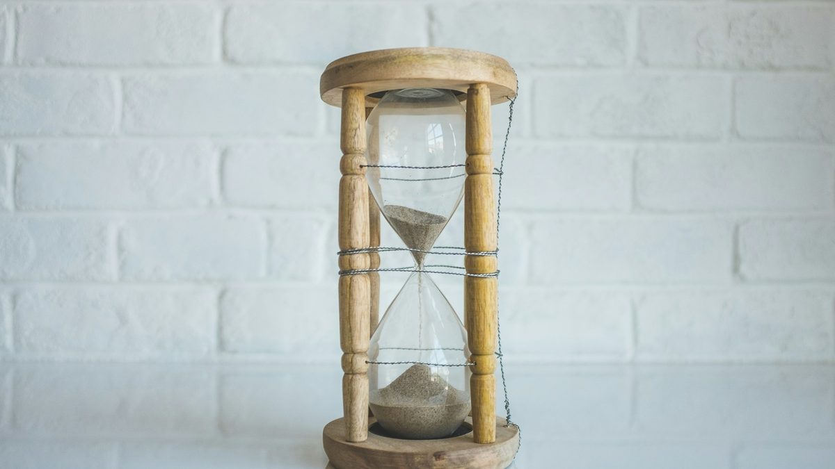A sand timer standing beside a game on a table