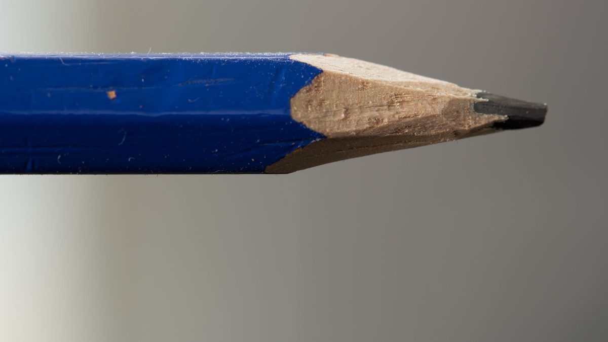 Extreme close-up of a sharpened pencil tip showing the exposed graphite core inside the wooden shaft
