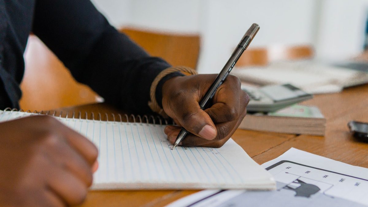 A person writing with their left hand