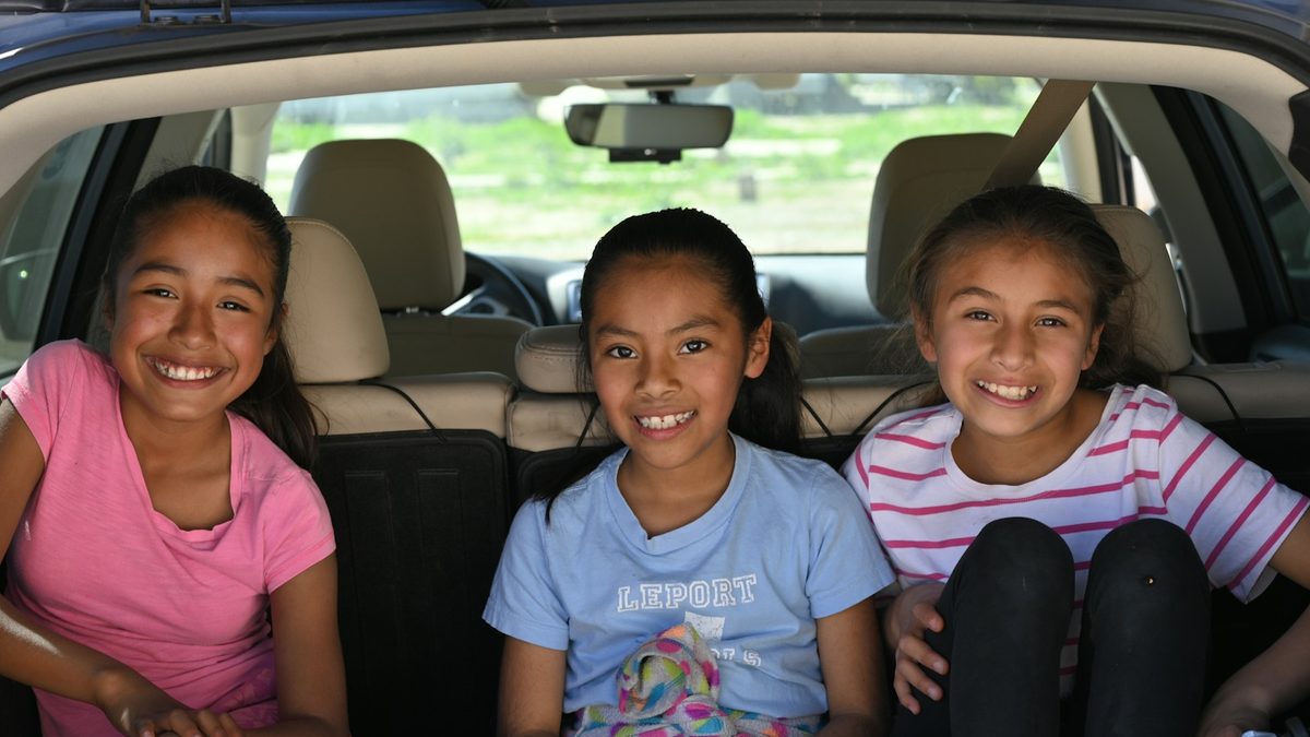 Children talking together in the back of a car on a journey
