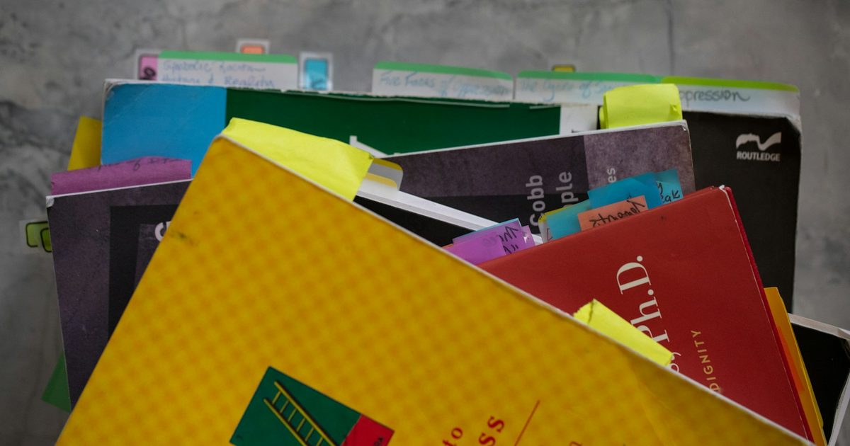 A stack of school exercise books and notebooks
