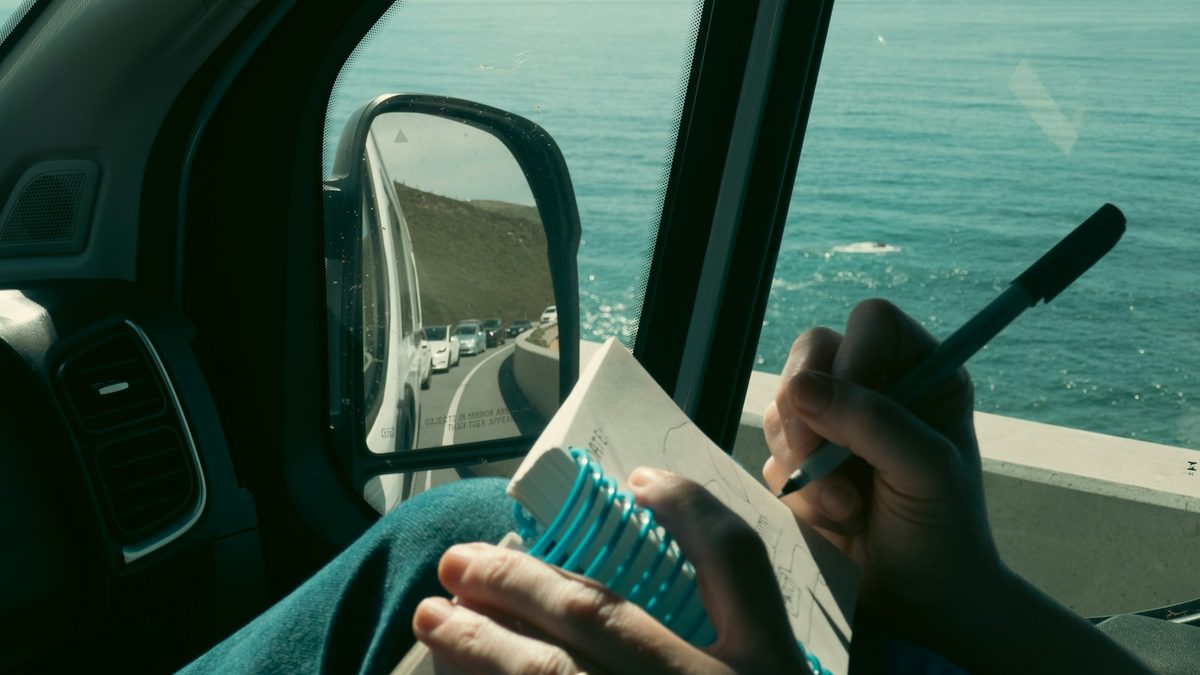 A child writing in a notebook while travelling