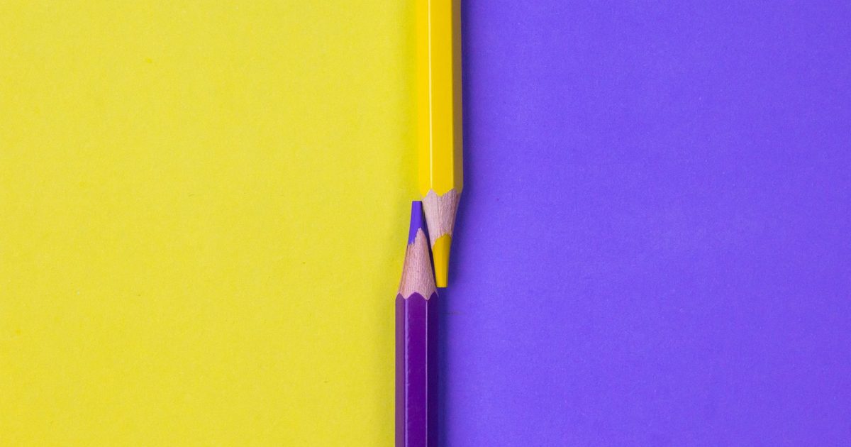A pen and a pencil lying side by side on a notebook