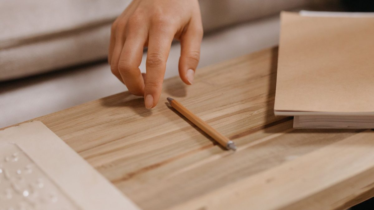 A pencil balanced horizontally across a fingertip