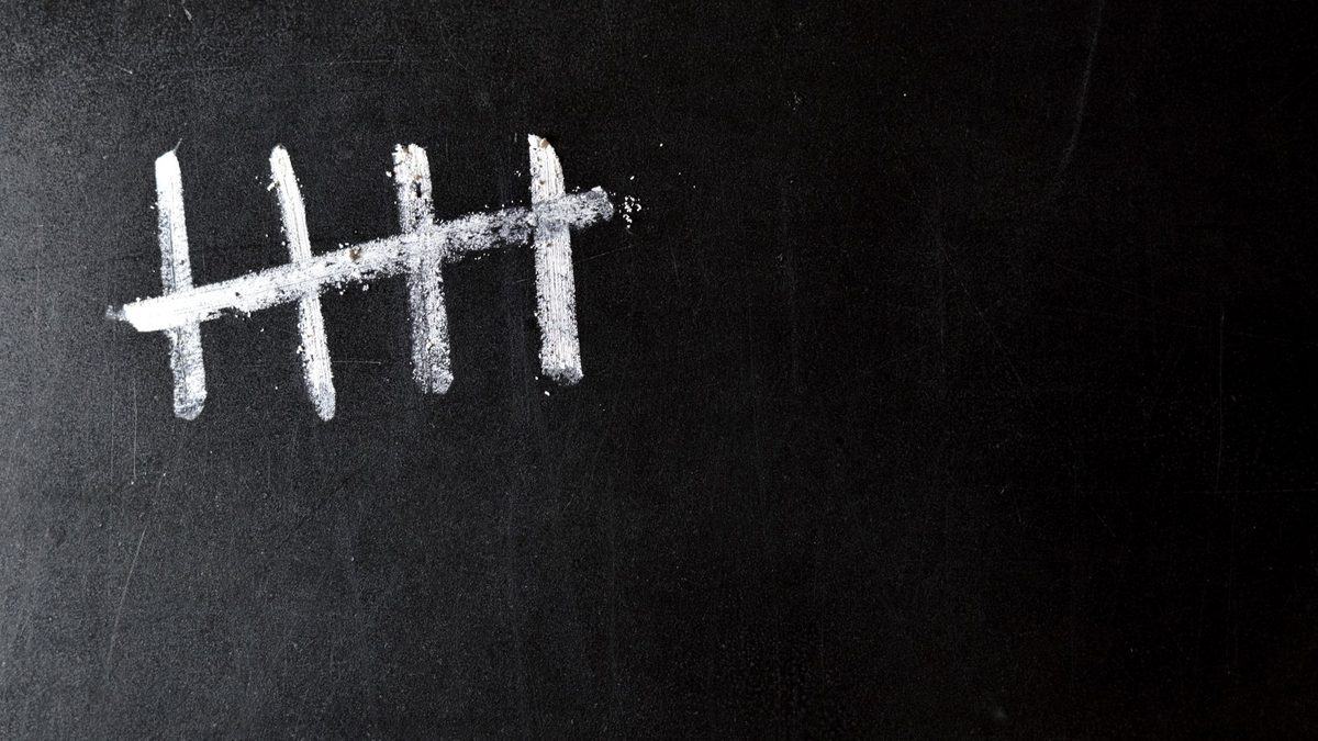 Tally marks being recorded by hand on paper