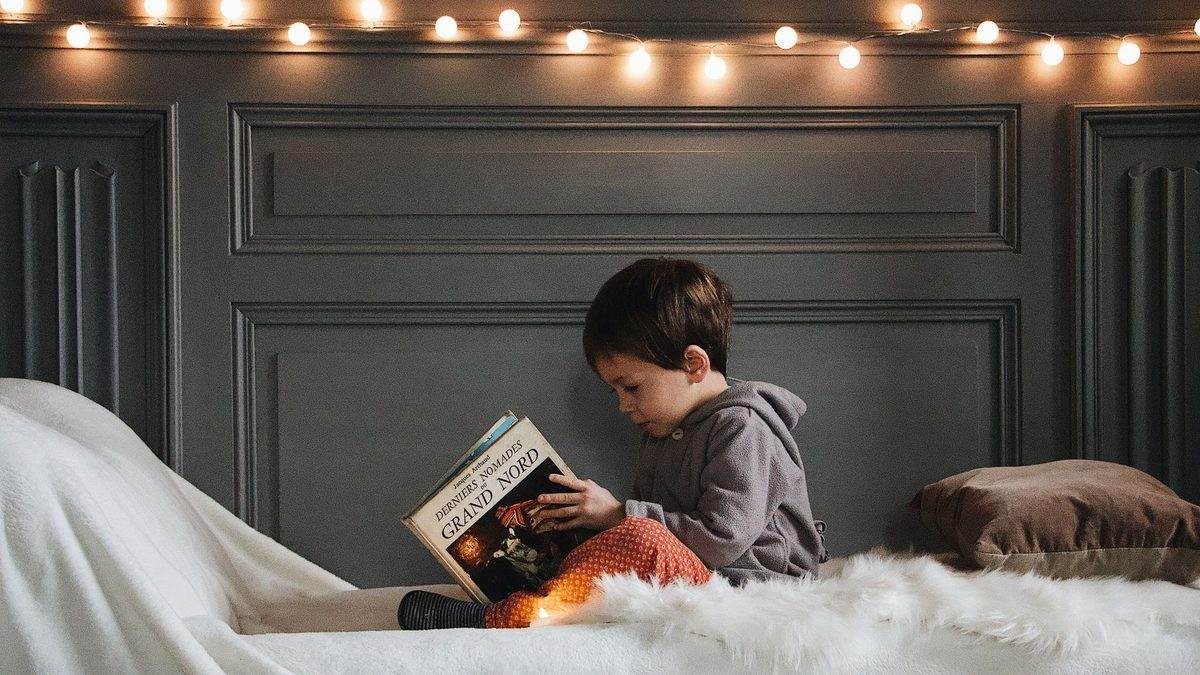 A child curled up reading a book at home