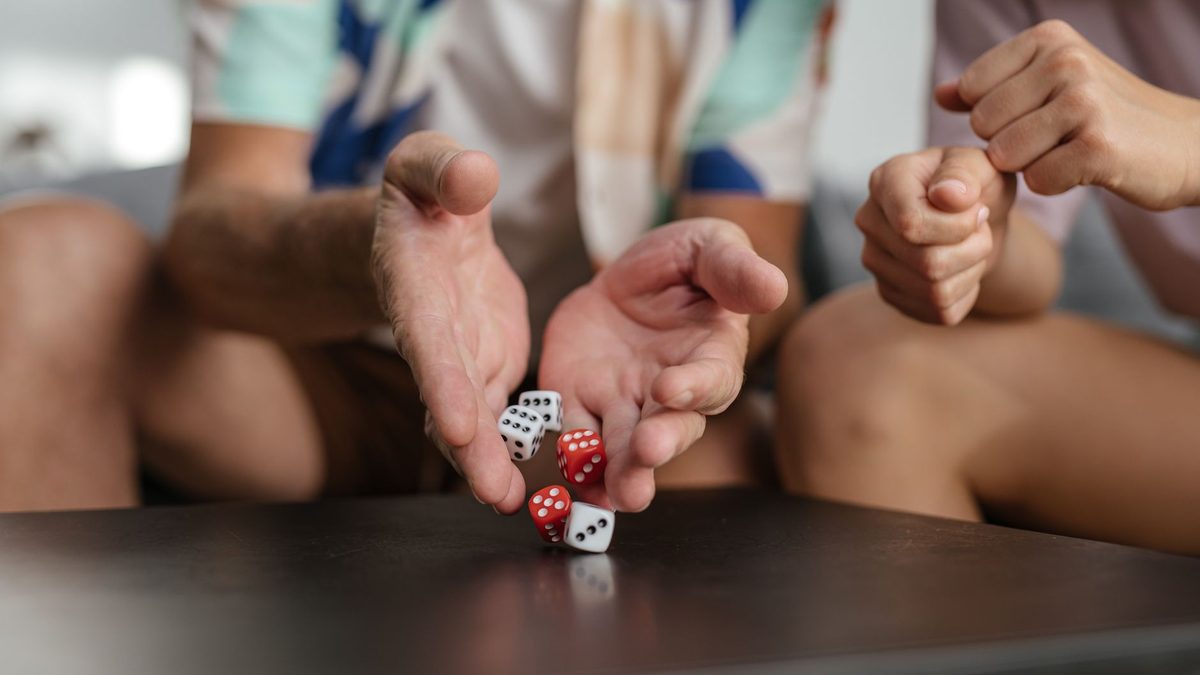 A hand rolling dice across a table