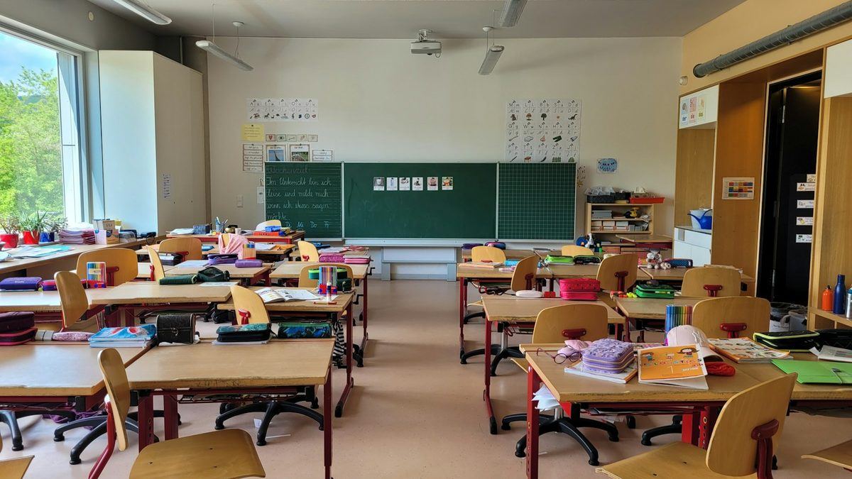 An empty school classroom filled with rows of desks and chairs