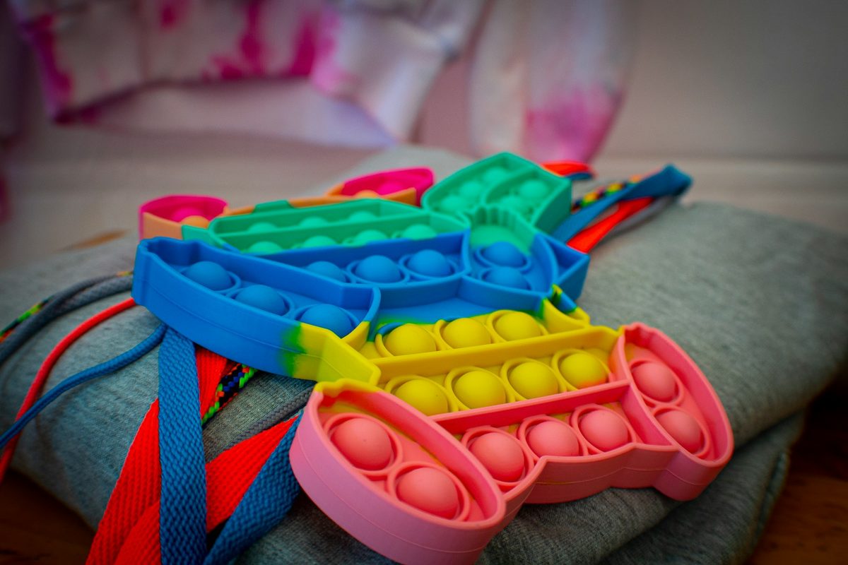 Colourful silicone push-button fidget toys resting on a soft surface