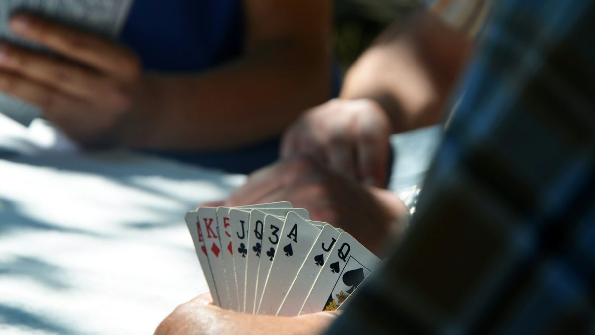 Hands reaching quickly for cards during a fast card game