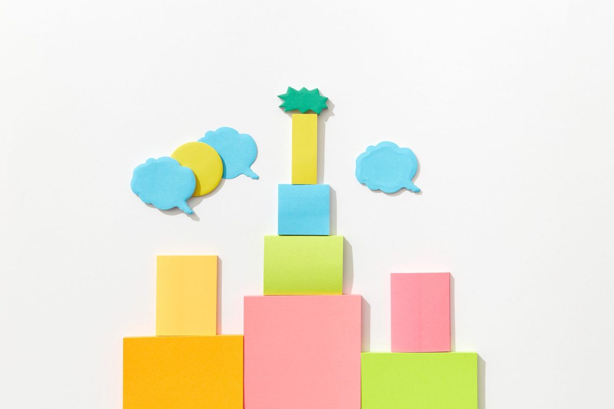 Brightly coloured paper shapes arranged on a pale background