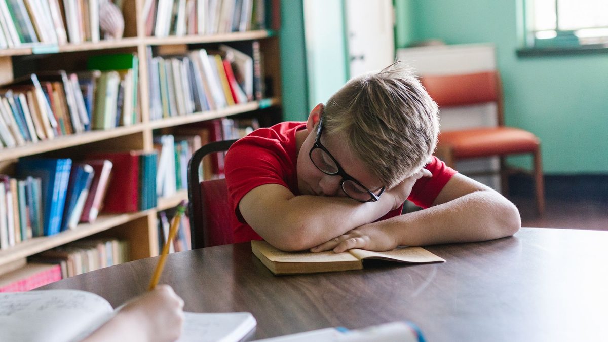 A tired child slumped at a table after school