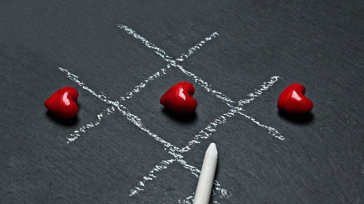 A tic-tac-toe grid drawn out and played with contrasting symbols