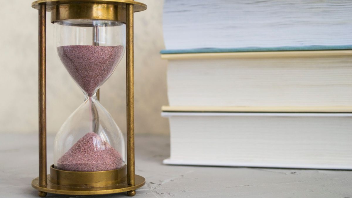 A timer standing beside school books during homework