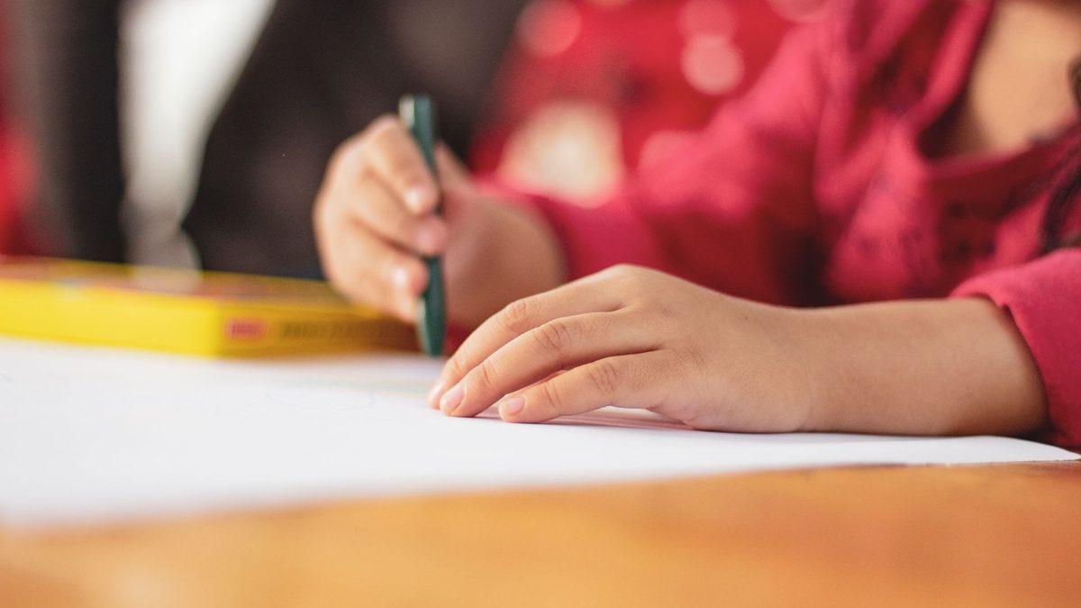 A toddler holding a crayon in a whole-fist grasp