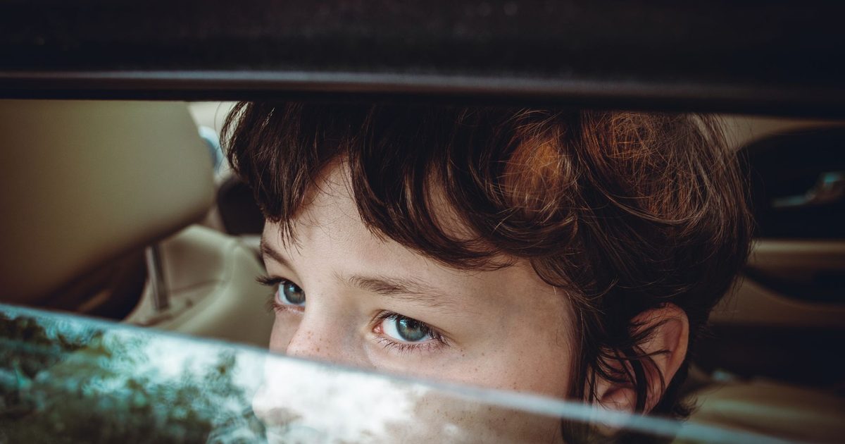 A child looking out of the window of a car during a journey