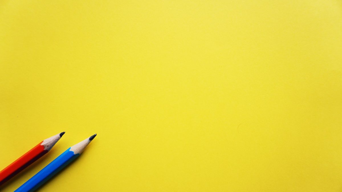 Two children sharing a single pencil at a desk