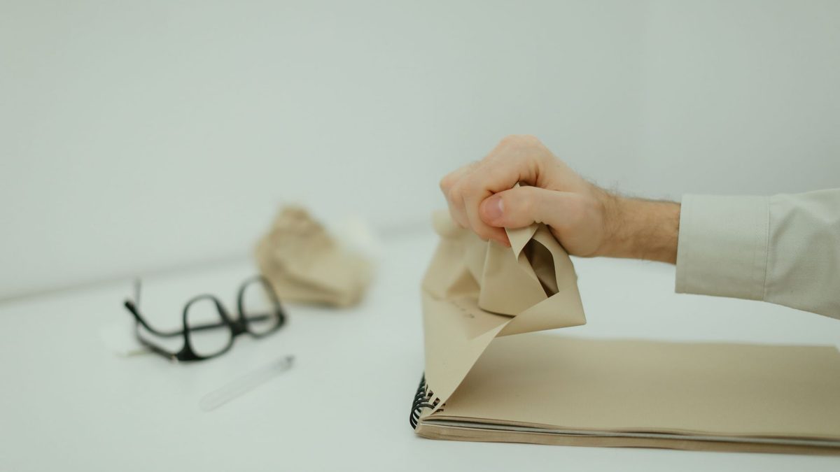 A frustrated child beside a crumpled sheet of paper