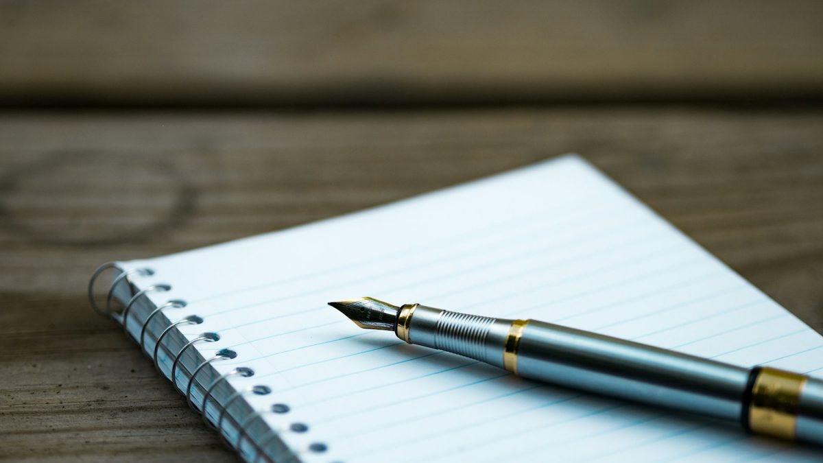 A blank page with a pen resting on it while procrastinating