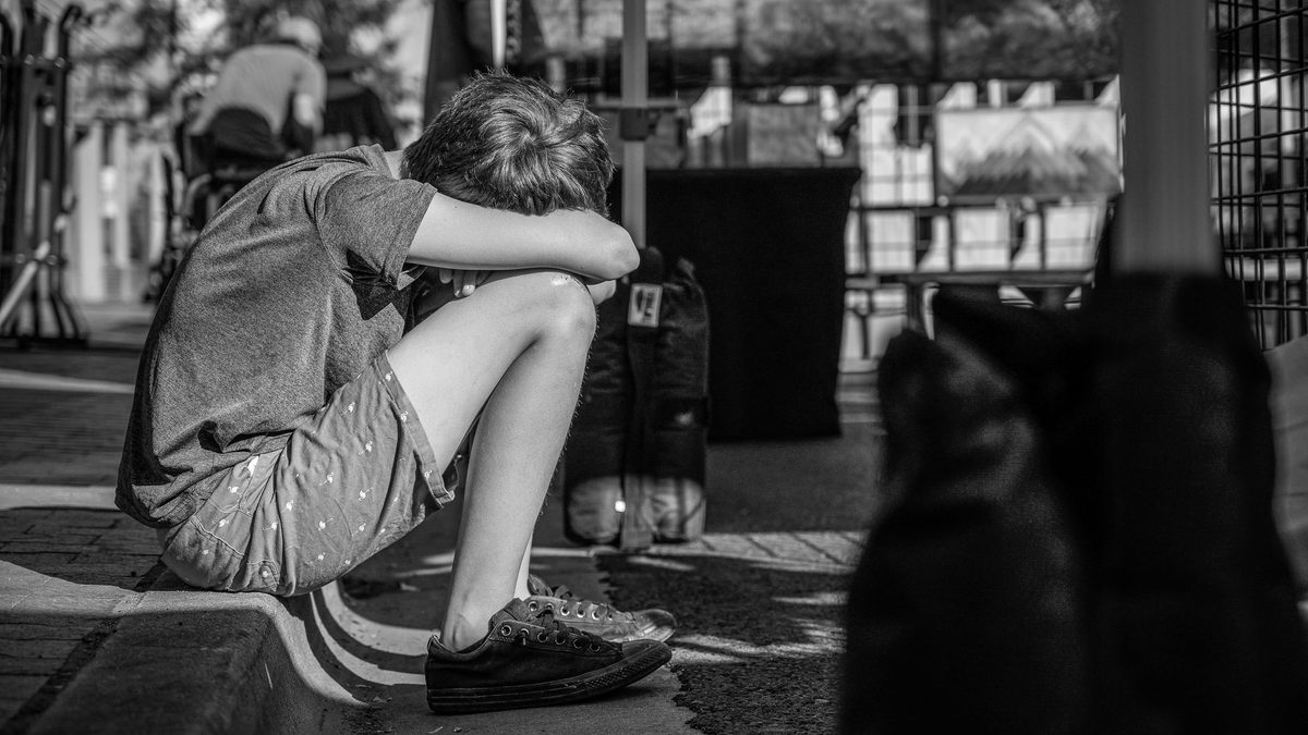 An upset child sitting alone after losing a game