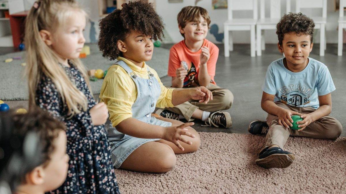 A class of children participating together with hands raised