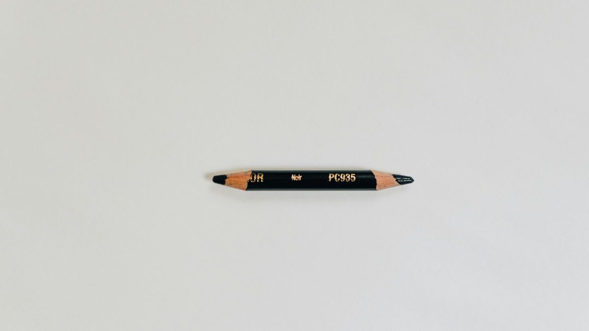 A single classic yellow wooden pencil on a plain background