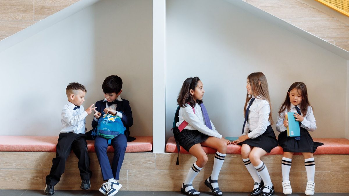 Children talking and playing together in the back seat of a car
