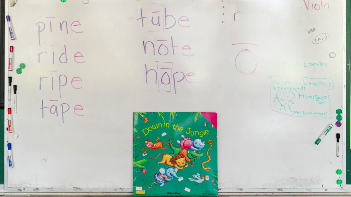 A child practising writing words on a whiteboard